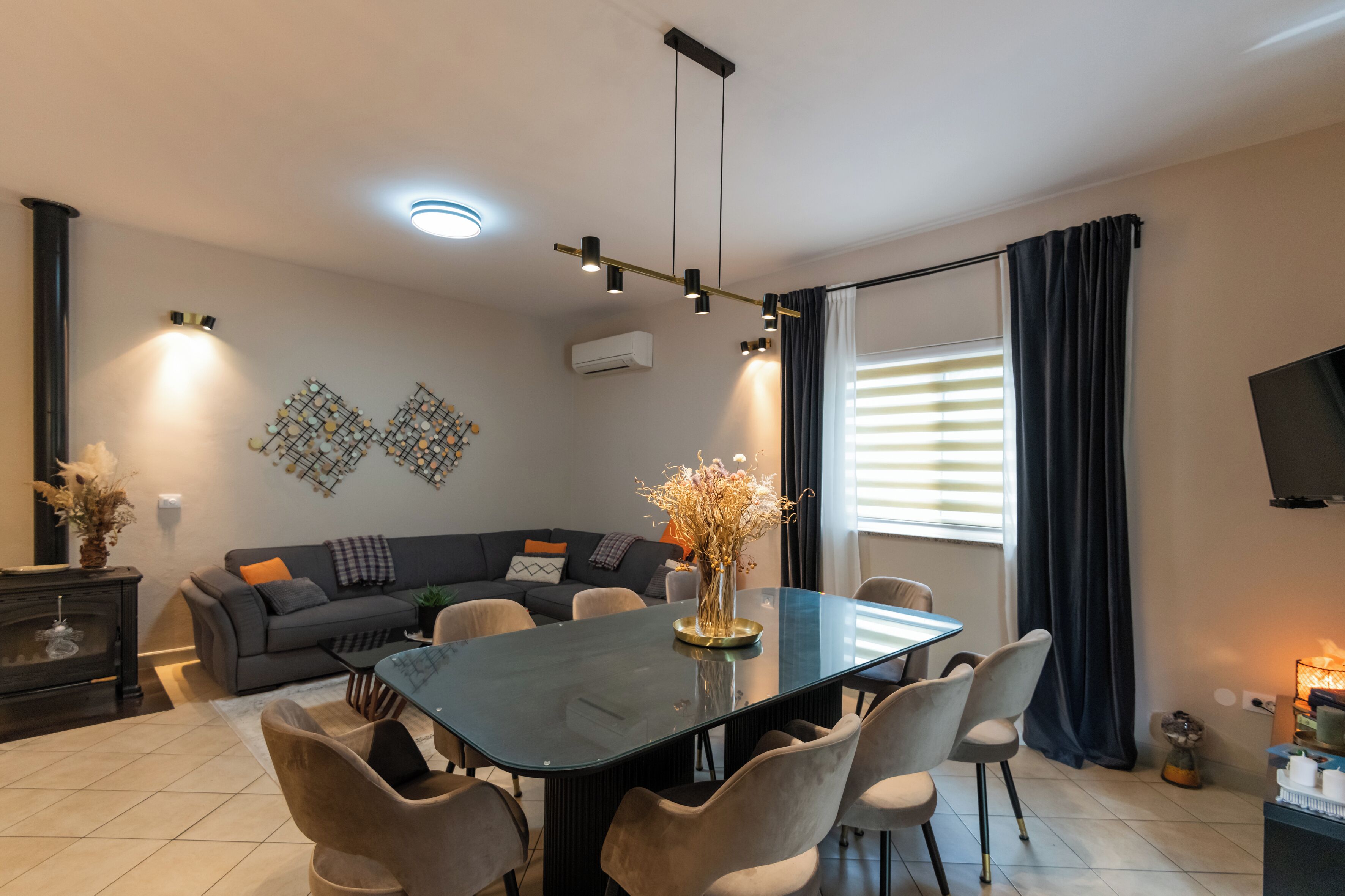 Una sala de estar moderna con una mesa de comedor, sofá y televisor.