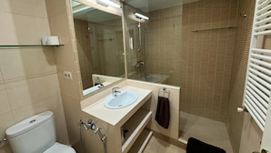 Un bagno moderno con toilette, lavabo e doccia.