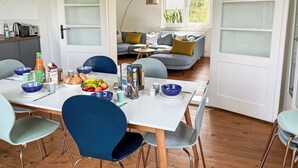 Un espace repas avec une table blanche, des chaises bleues et une variété de plats.