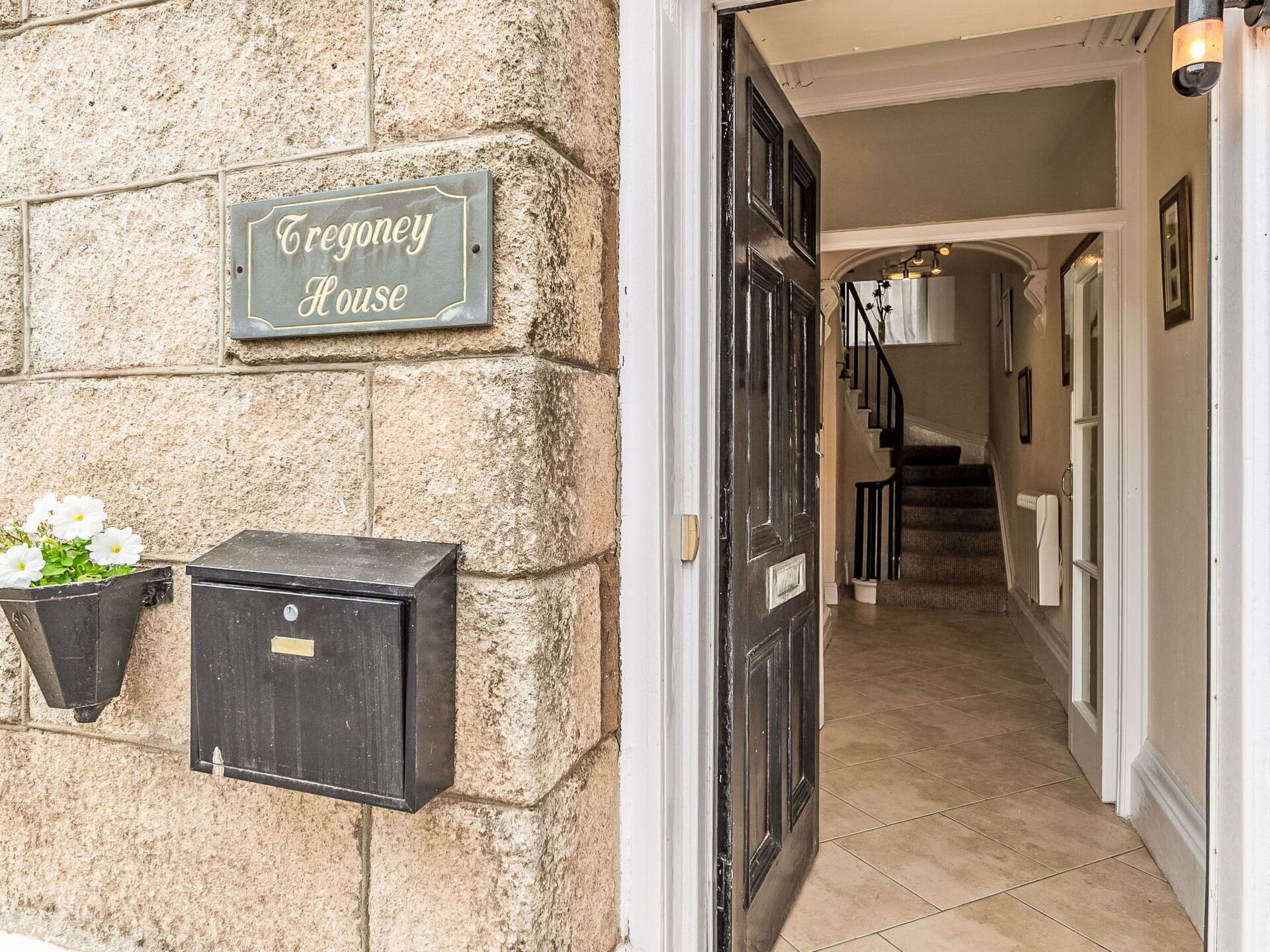 A stone building entrance with a sign reading "Treegoney House."