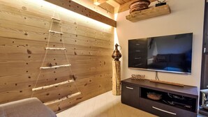 Una sala moderna con un muro de madera, un televisor de pantalla plana y un mueble de madera.