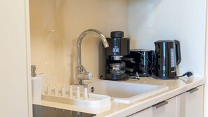 A modern kitchen with a built-in coffee maker, a sink, and a countertop. - Beautiful apartment for 3 guests with A/C, WIFI, TV and balcony (Strobl)