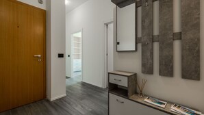Un baño moderno con puerta de madera, tocador con espejo y zona de ducha.