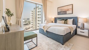 A modern bedroom with a large bed, bedside tables, a desk, and a view of the city. - Creek Views 1BR, Short Drive to Ras Al Khor Sanctuary and Festival City Mall (Dubai)