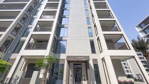 A modern high-rise building with multiple balconies and a central entrance. - Creek Views 1BR, Short Drive to Ras Al Khor Sanctuary and Festival City Mall (Dubai)