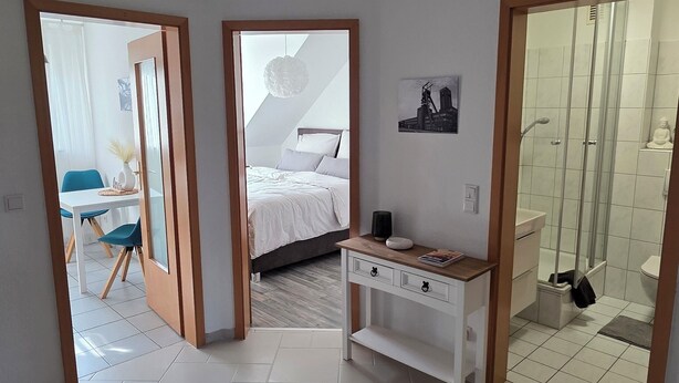 Una habitación amplia con cama, escritorio y zona de ducha.