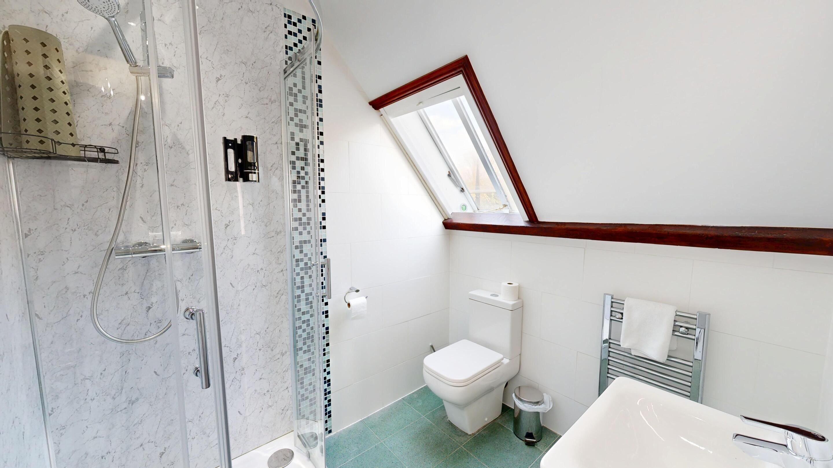 A bathroom with a shower, toilet, and bathtub.