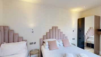 Une chambre d’hôtel avec deux lits, chacun doté d’une tête de lit, et une grande armoire.