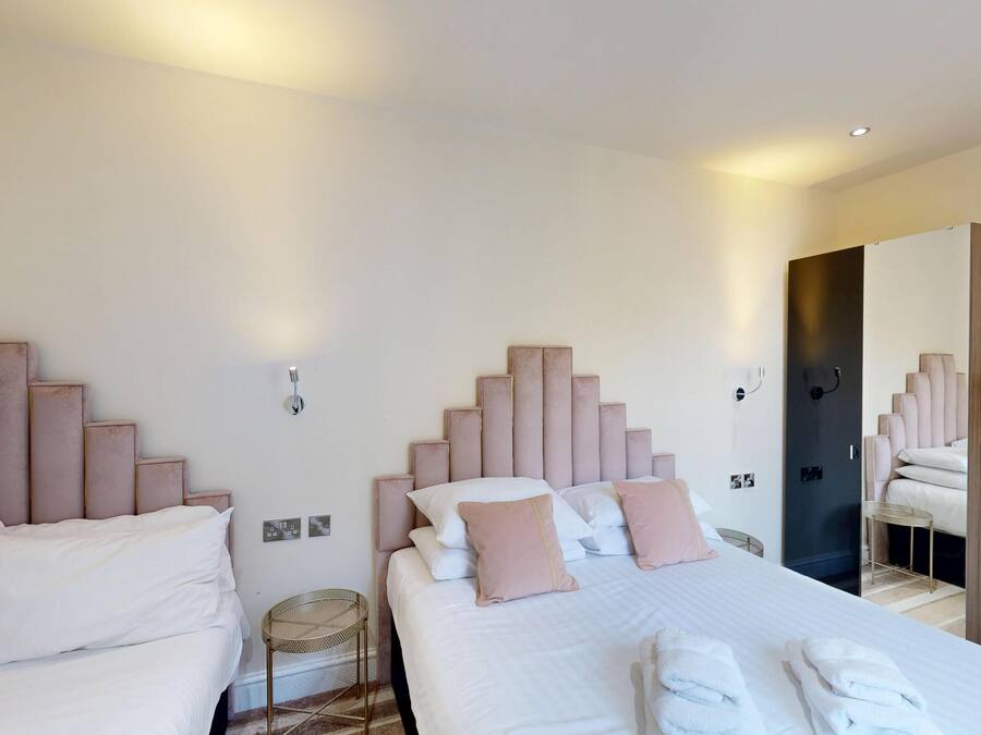 Une chambre d’hôtel avec deux lits, chacun doté d’une tête de lit, et une grande armoire.