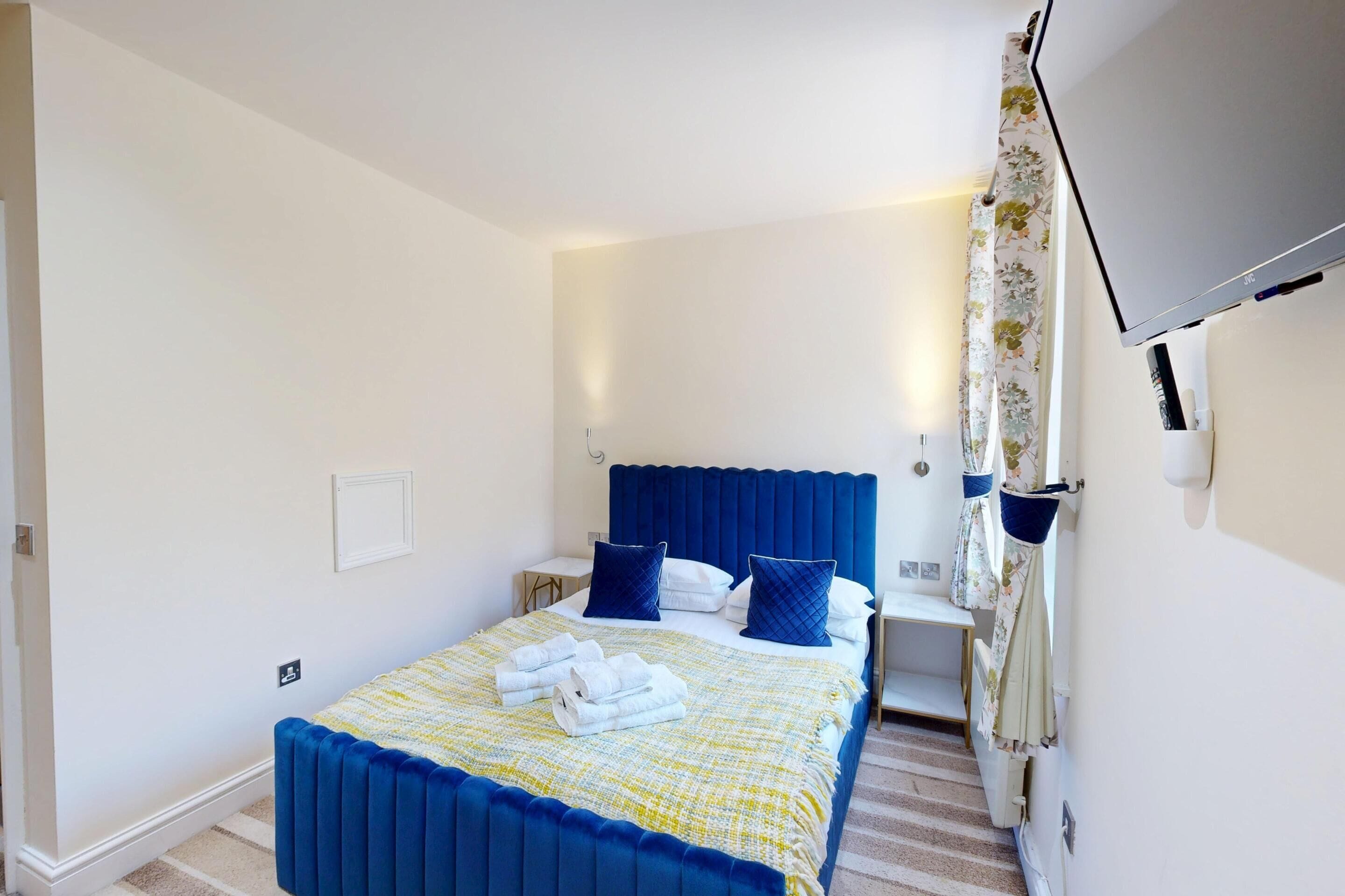Une chambre à coucher avec un lit, une télévision et une salle de bain.