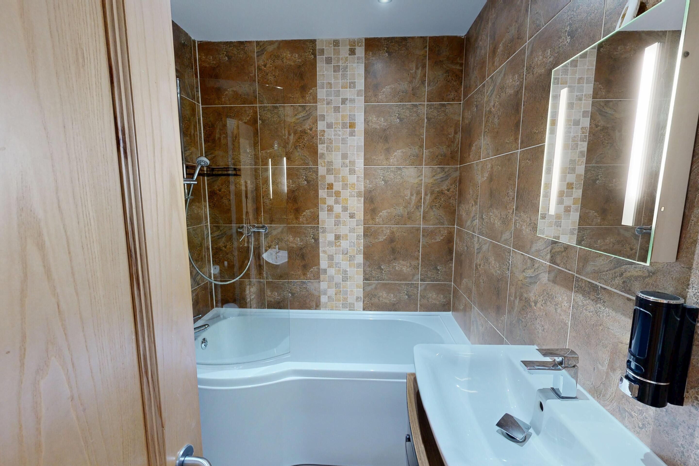 Un baño moderno con una bañera grande, una zona de ducha independiente y un tocador con espejo.