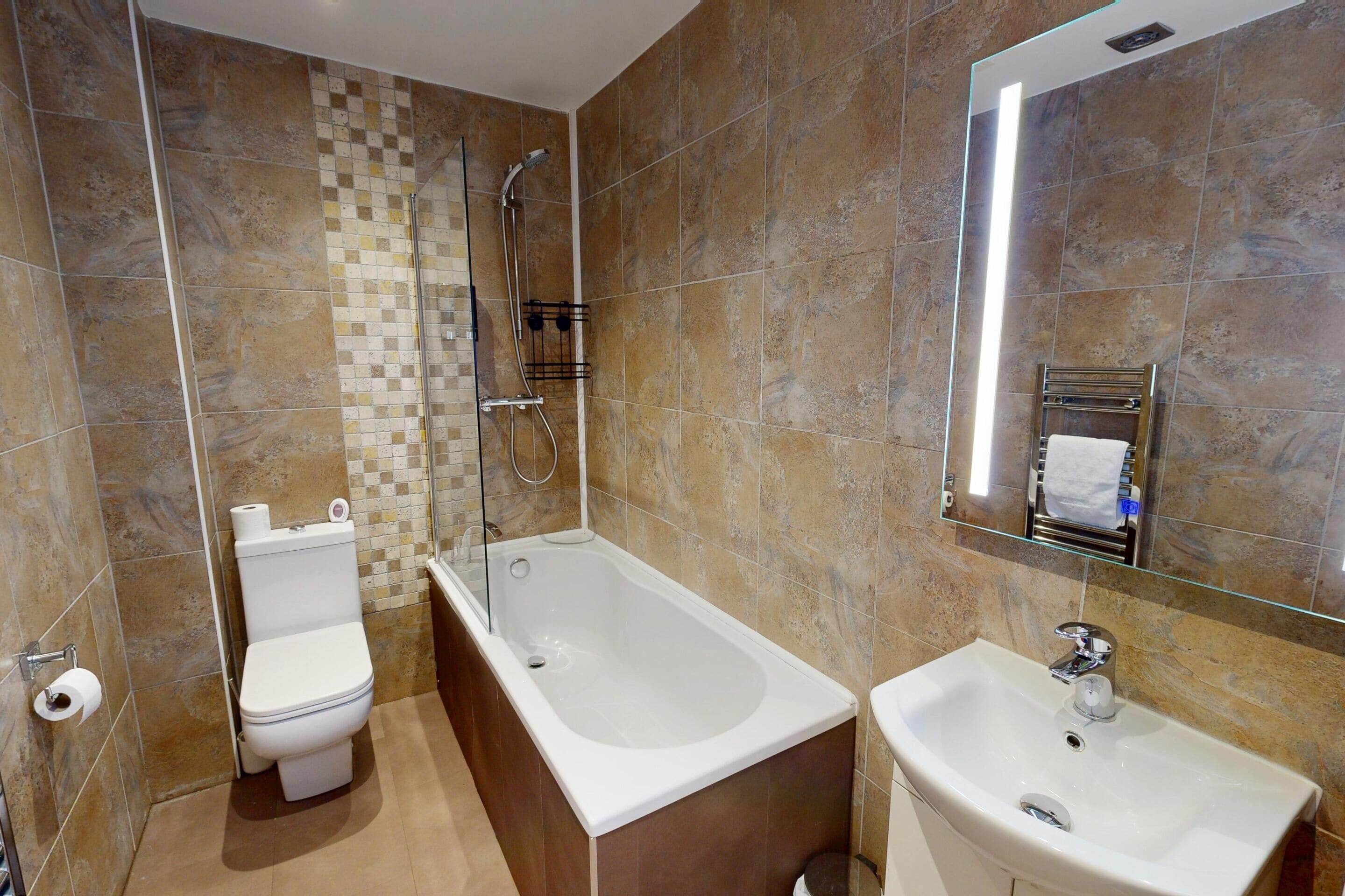 A bathroom with a toilet, bathtub, and sink.