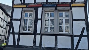 Ein traditionelles Fachwerkhäuschen mit zahlreichen Fenstern und einem steilen Satteldach.