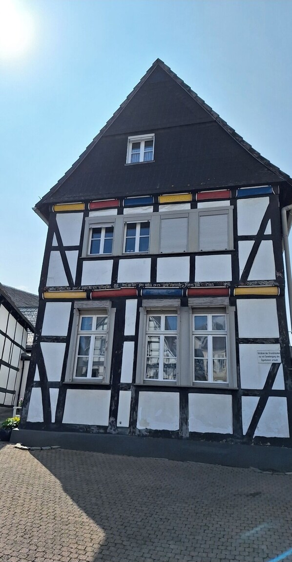 Un edificio tradicional de entramado de madera con numerosas ventanas y un tejado empinado.
