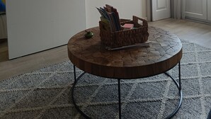 A room with a white door, a mounted flat-screen TV, a round wooden table with a woven basket, and a patterned rug. - Porto Alma 388 - Silent City center (Porto)