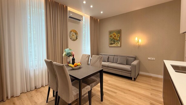 Una sala de estar moderna con una mesa de comedor, sofá y un cuadro en la pared.