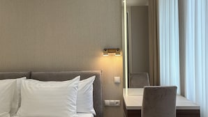 Una habitación de hotel moderna con una cama, un escritorio y una silla.