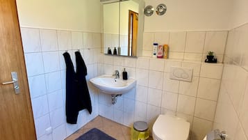 Ein Badezimmer mit Waschbecken, Toilette, Spiegel und Handtuchhalter.