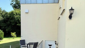 A building with a small outdoor seating area, a door, and a lamp post. - Weserglück vacation apartment Grohnde (Emmerthal)