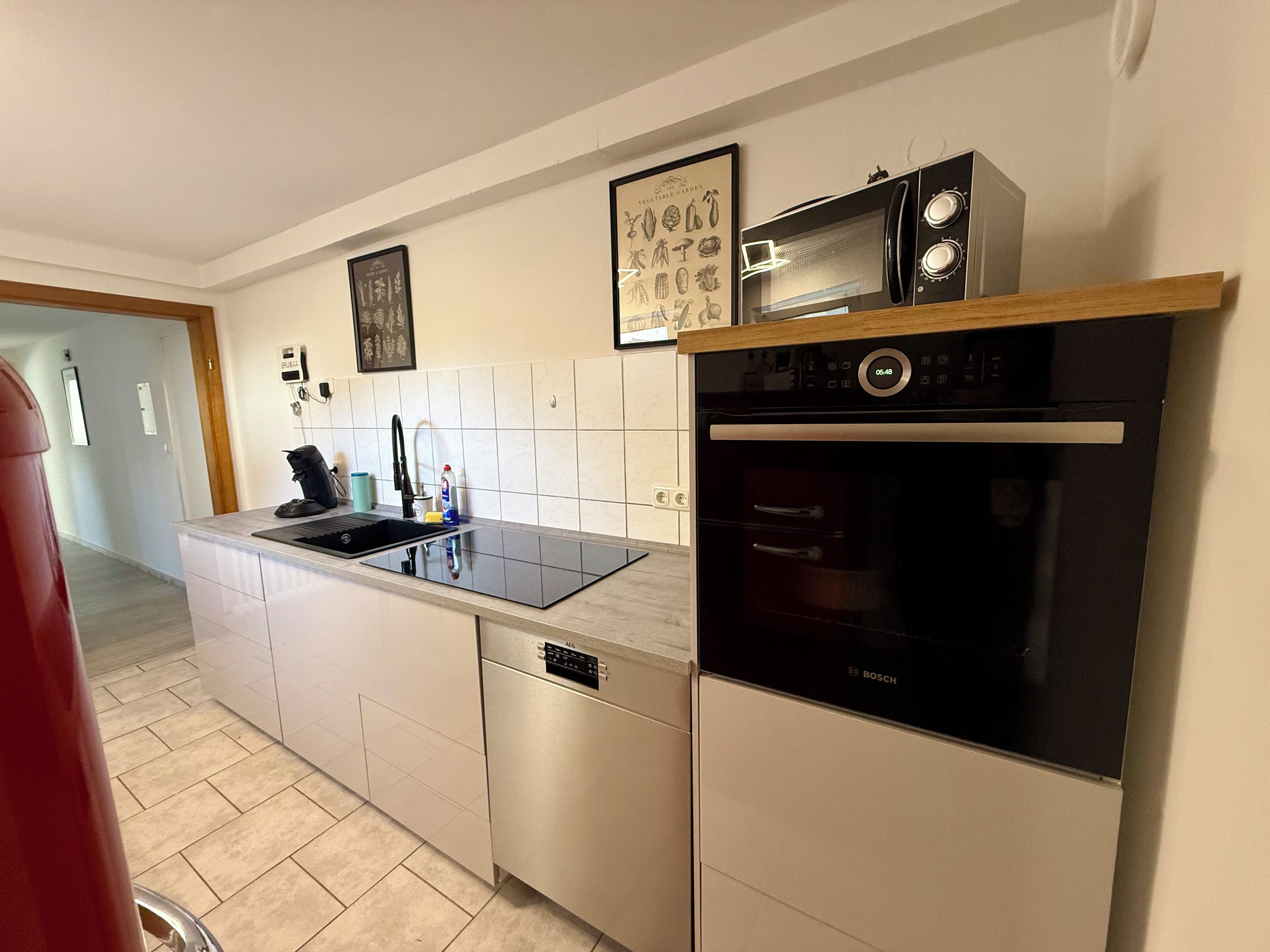 A modern kitchen with a Bosch dishwasher, a microwave, and a built-in oven.