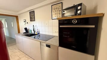 A modern kitchen with a Bosch dishwasher, a microwave, and a built-in oven.
