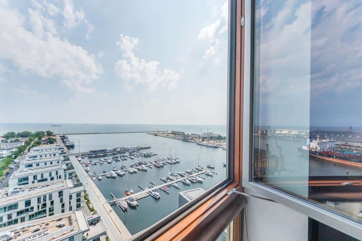 A high-rise building with a view of a marina and port.
