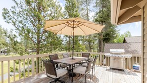 A deck with a table and chairs, an umbrella, and a grill. - 7 Vine Maple 4 Bedroom Home (Bend)