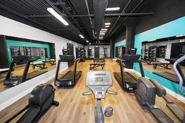 A gym with treadmills, elliptical machines, and weightlifting equipment.