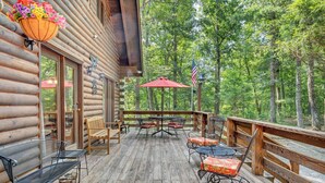 A log cabin with a wooden deck, outdoor seating, and a view of the forest. - Eagles Rest~ Grand, Luxurious & Peaceful— Near Hiking Trails & Virginia Tech! (New Castle)