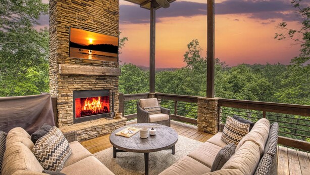 A stone fireplace with a fire, outdoor seating, and a view of the landscape. - Mountain Dream’n- modern, dog friendly, hot tub (Blue Ridge)