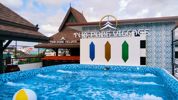 A swimming pool with a view of a building labeled "The Pears Village." - THA PHAE VILLAGE (Chiang Mai)