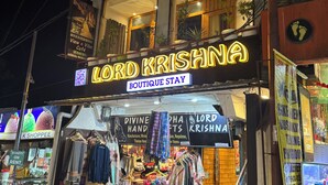 A two-story building with a sign for "View n' Vibe Cafe" and "Lord Krishna Boutique Stay". - Lord Krishna Boutique Stay (Dharamshala)