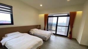 A hotel room with two beds, a large window with curtains, and a view of an airport. - Sky BnB (Donggang)