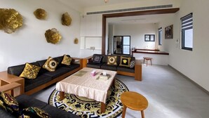 A spacious living room with a sofa set, a coffee table, and decorative wall pieces. - Sky BnB (Donggang)