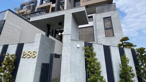 A modern building with a concrete facade, numbered 286, featuring a mix of balconies and large windows. - Sky BnB (Donggang)