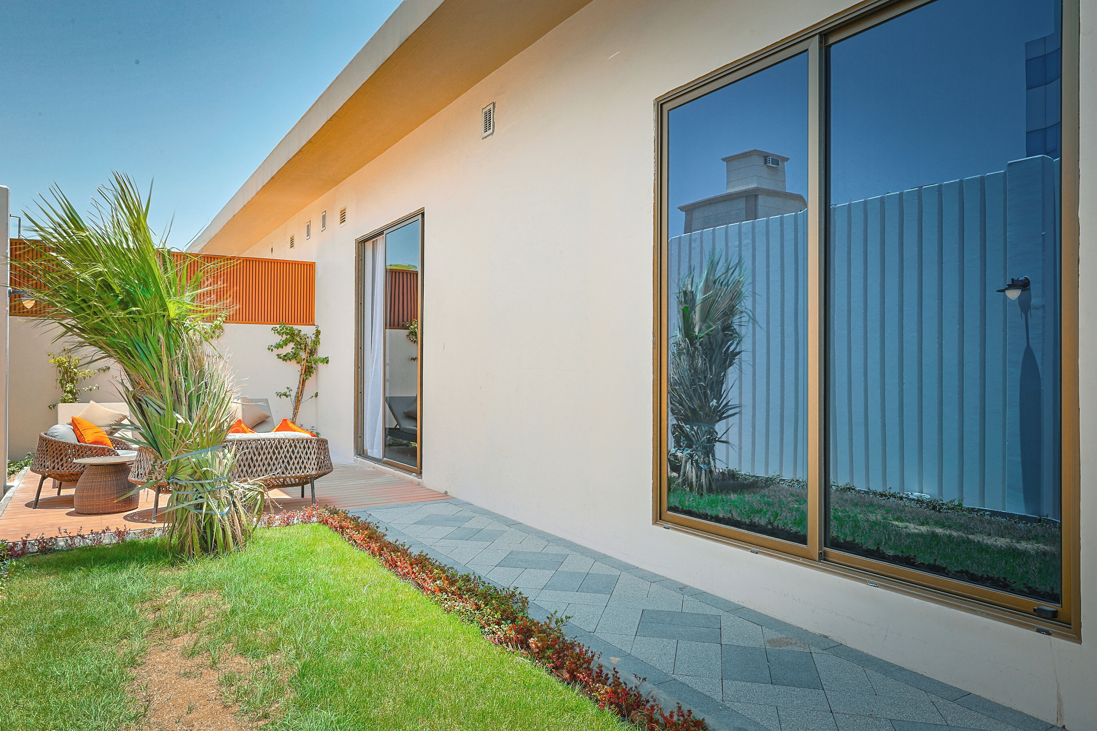 A modern house with a patio area featuring outdoor furniture and a small garden.
