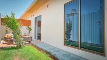 A modern house with a patio area featuring outdoor furniture and a small garden.