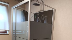 Een moderne douchecabine met een glazen deur en douchekop.