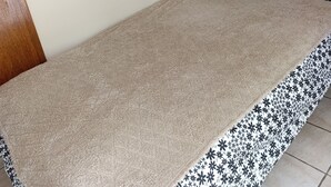 Een kamer met een beige vloerkleed, een decoratieve rand, een donkere muur en een lichtschakelaar op de witte muur.