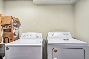 Zwei weiße Whirlpool Trockner in einem Waschraum mit einem Karton und einem kleinen Gerät auf der linken Seite.