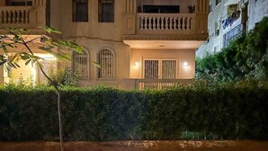 A building with a balcony and a hedge in front. - 6th Of October Signature Stay (6th of October City)