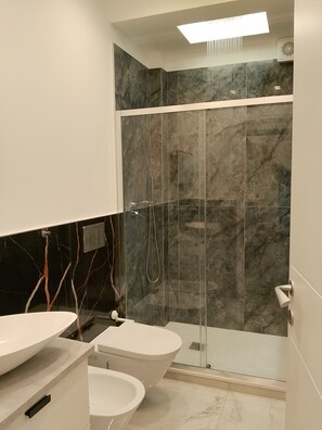 Een douche, een haardroger, een bidet, handdoeken