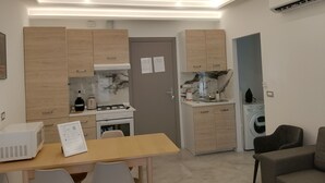 Una cocina compacta con armarios de madera, estufa integrada y microondas.