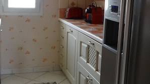 A compact kitchen with a refrigerator, a toaster, and a microwave.