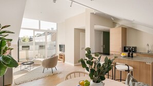 Un apartamento moderno con comedor, cocina y un amplio ventanal con vista a la ciudad.