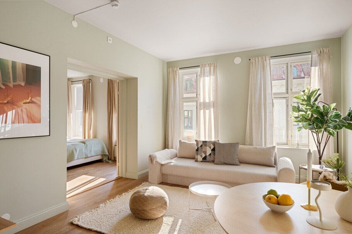 A modern living room with a sofa, coffee table, and a bowl of fruit.
