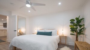A modern bedroom with a large bed, bedside tables, a ceiling fan, and a potted plant. - Boomerang 202: New remodel! (Telluride)