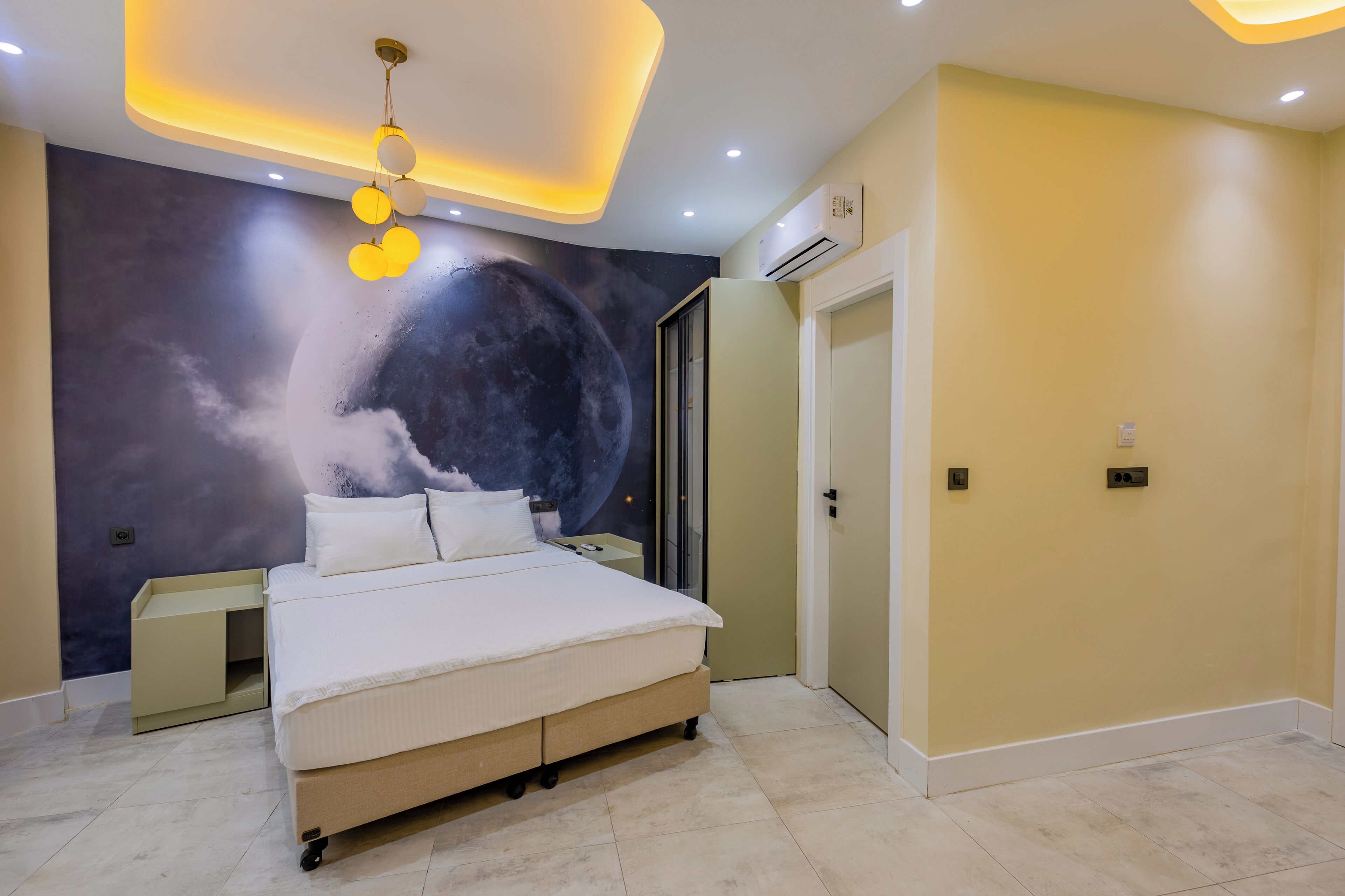 A modern bedroom with a large bed, a wall mural, and a ceiling light fixture.