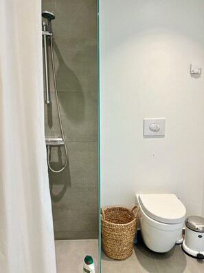 Een douche, handdoeken, zeep, toiletpapier