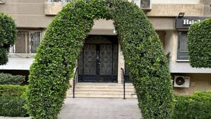 A building entrance with a large, arched, green hedge. - GroundFloor Serenity (Cairo Governorate)